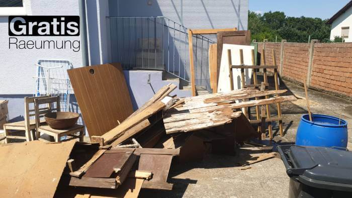 ein Abfallhaufen vor dem Haus, bestehend aus alten Stühlen, Türen und verschiedenen Brettern. räumung, die darauf wartet, gemacht zu werden.